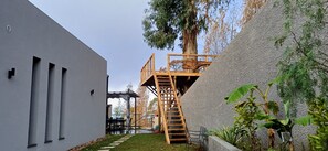 Experience the serene ambiance of Casa da Vovó, where a modern building meets lush greenery and functional outdoor spaces.