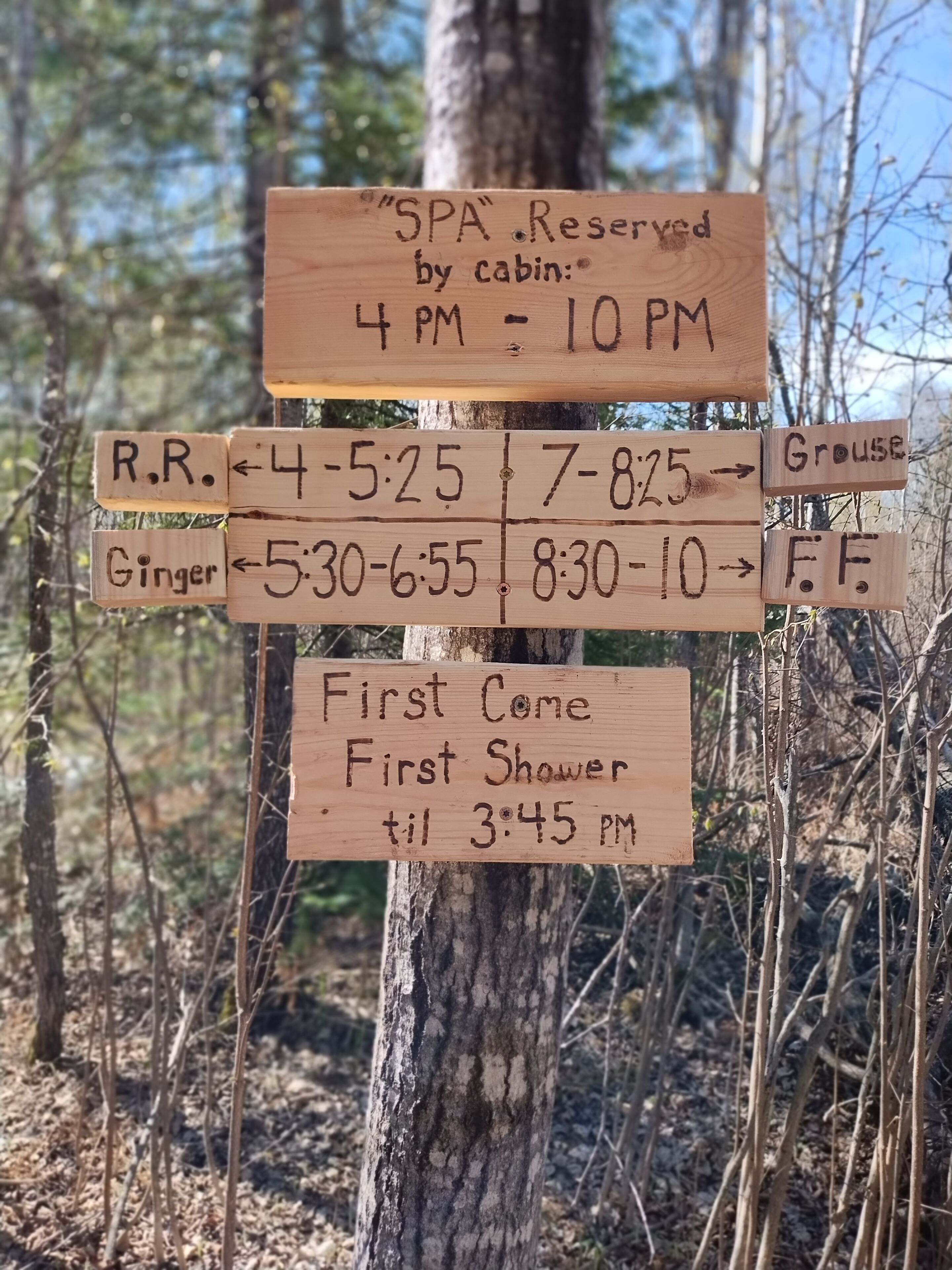 Un panneau indicateur en bois affichant les plages horaires disponibles pour la réservation des cabines et les services proposés.