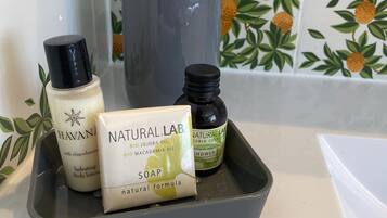 Una encimera de baño con dispensador de jabón, una botella de loción corporal y una botella de gel de ducha.