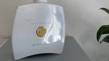 A white ceramic diffuser with reed sticks, labeled "GREEN CARDA PRIVATE COLLECTION RITUALS."