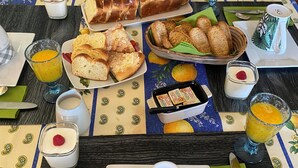 Een ontbijtbuffet met diverse gebakjes, brood en drankjes.