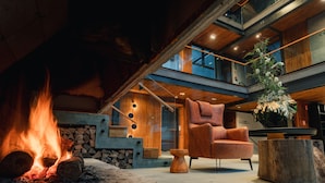 A modern interior with a fireplace, wooden furniture, and a plant. - 249 DESIGN HOTEL (Gramado)