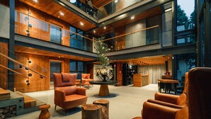 A spacious, multi-level interior with modern furnishings, including leather sofas and a central wooden table with a floral arrangement. - 249 DESIGN HOTEL (Gramado)