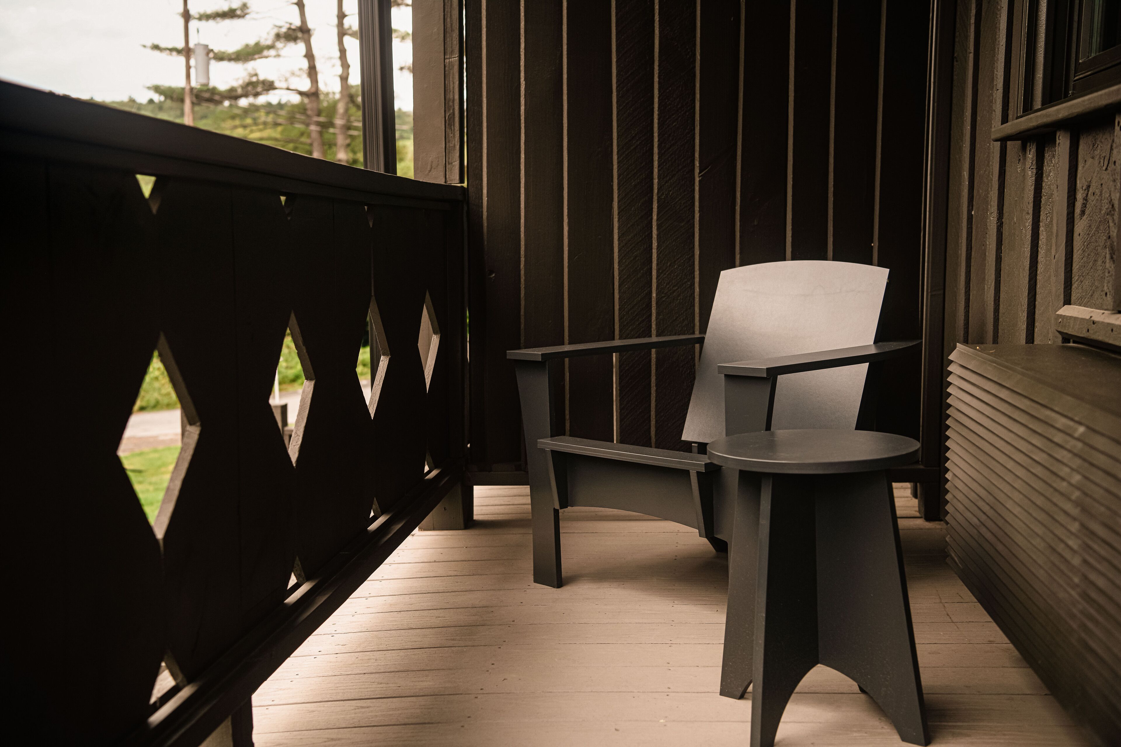 A wooden deck with a chair and a table.