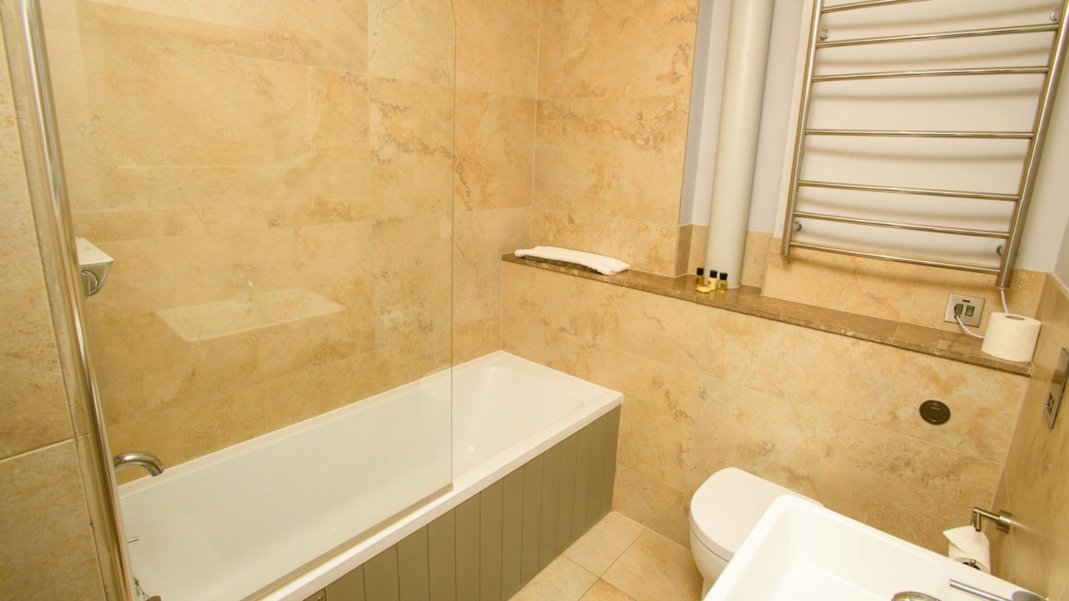 A bathroom with a bathtub, toilet, and a shower area.