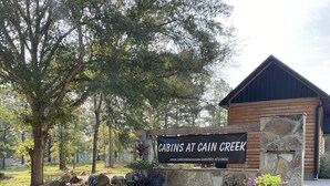 Eine Holzhütte mit Steinverkleidung und einem Schild, auf dem "CABINS AT CAIN CREEK" steht.