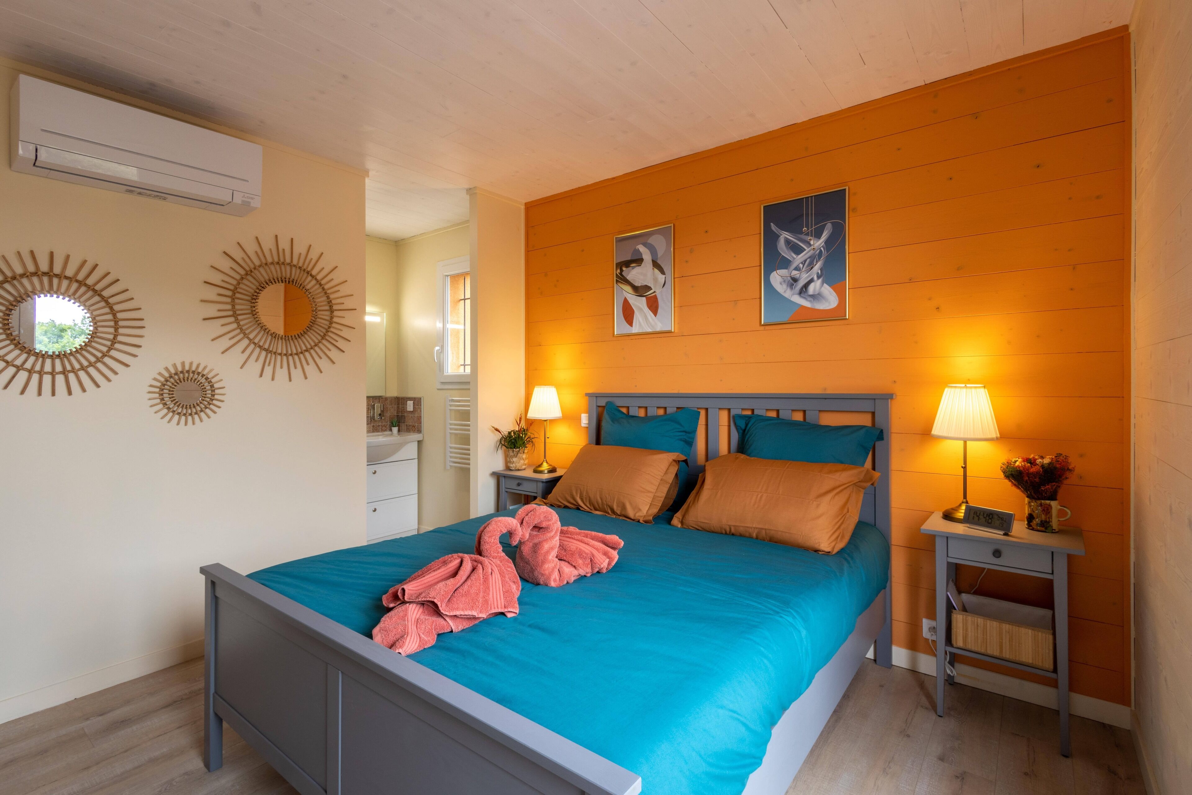 Un dormitorio con cama, dos mesitas de noche, aire acondicionado de pared y decoración mural.