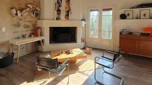 Un salon doté d’une cheminée, de planchers en bois et de meubles modernes.