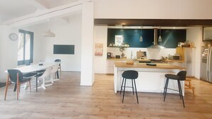 Une cuisine moderne dotée d’un îlot central, de tabourets de bar et d’un coin repas avec une table et des chaises.