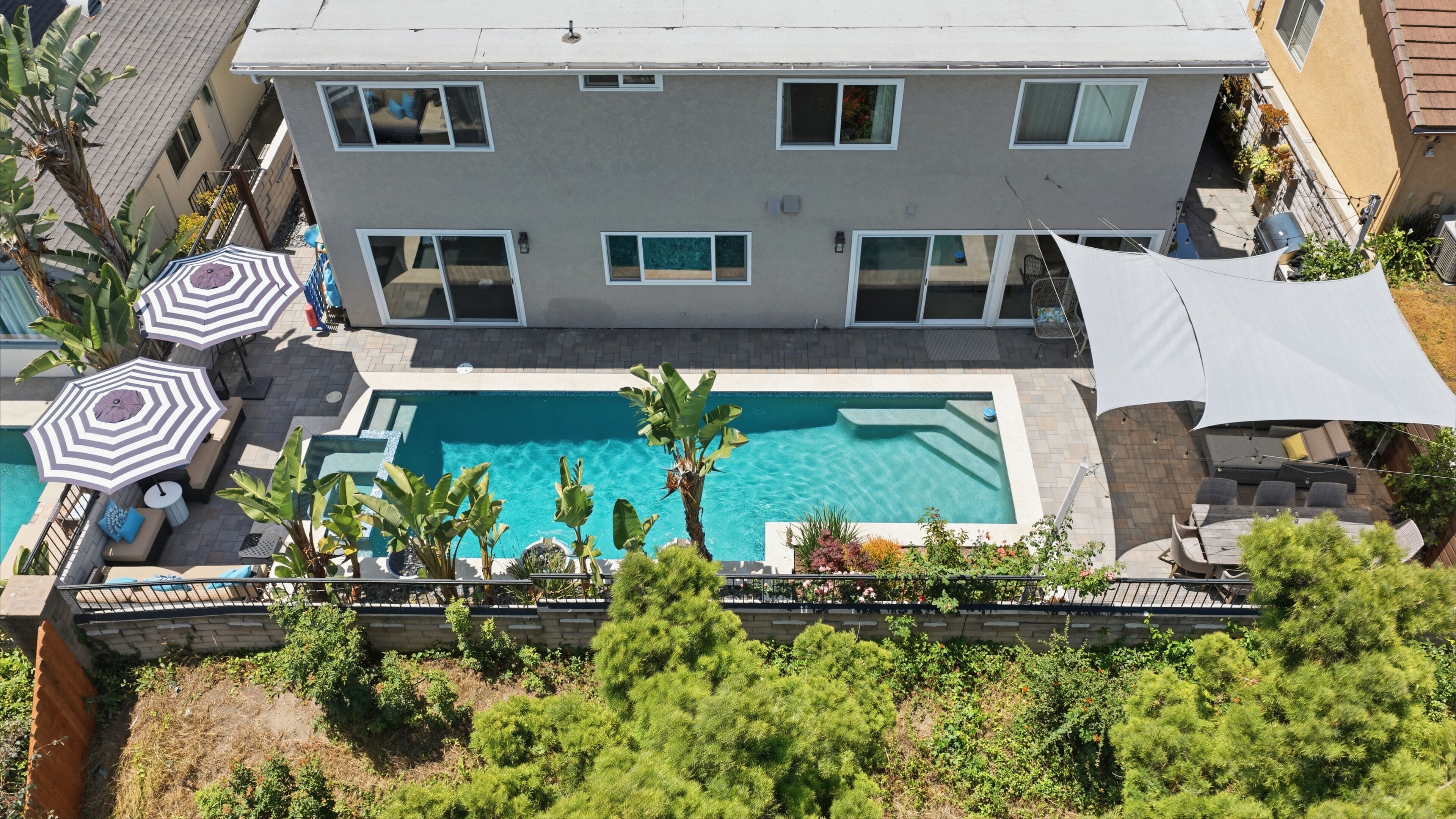 Un immeuble résidentiel doté d’une piscine, d’un espace extérieur aménagé et d’un patio couvert.