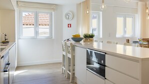 Una cocina moderna con una isla central, armarios blancos y un lavavajillas Bosch.