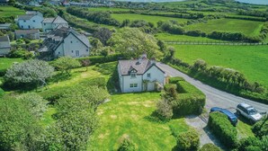 A large house with a well-maintained lawn and a driveway. - Dollars Cottage - 4 Bedroom Cottage - Llangennith (Swansea)