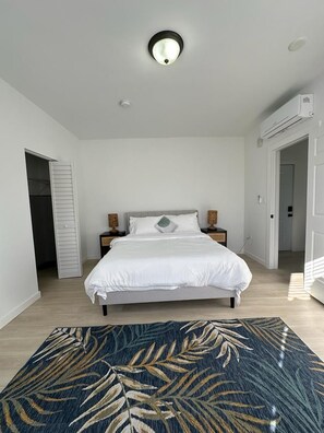 A bedroom with a bed, bedside tables, a ceiling light, and a door. - Havana Dreams by Pattio (Miami)