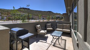 A patio with outdoor furniture, a grill, and a view of a hilly landscape. - Red Rock Oasis! Close to Adventure! Family Friendly! Amazing Pool! (Washington)