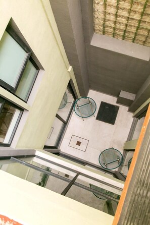 A modern interior with a high ceiling, large windows, and a central ventilation system.