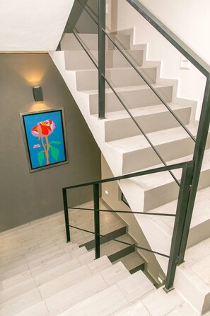 A staircase with a modern design, a wall-mounted picture, and a light fixture.