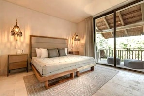 Relax in a serene bedroom with a large bed, bedside tables, and a sliding door leading to an outdoor area.