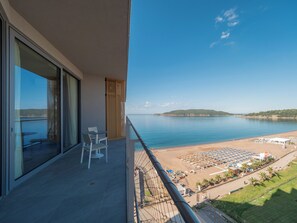 A balcony with a view of a beach and a distant island. - Sea Star Budva (Rafajlovici)