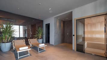 Un espace spa moderne comprenant deux chaises longues, une grande plante en pot et un sauna en bois.