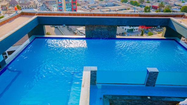 Una piscina con vista a un paisaje urbano al fondo.