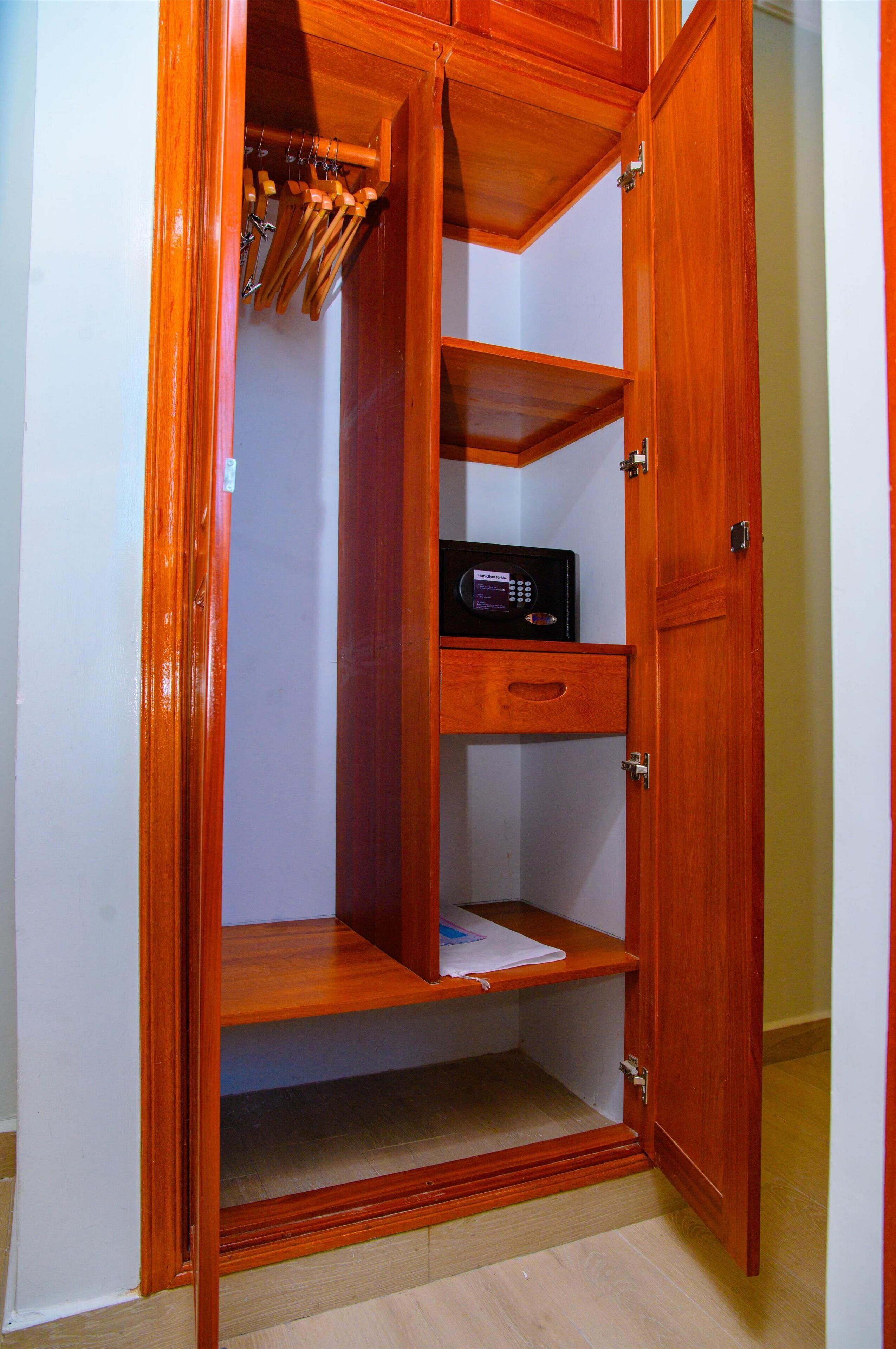 A wooden wardrobe with multiple shelves and a hanging rod.