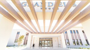 A modern building entrance with a glass door, a name sign above, and a clear sky. - Grand Elis Hotel  (Ilida)