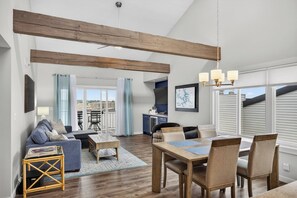 A spacious living area with a dining table, sofas, and a kitchen in the background. - Bridgepointe Condo - Two Bedroom Apartment, Sleeps 6 (Osage Beach)
