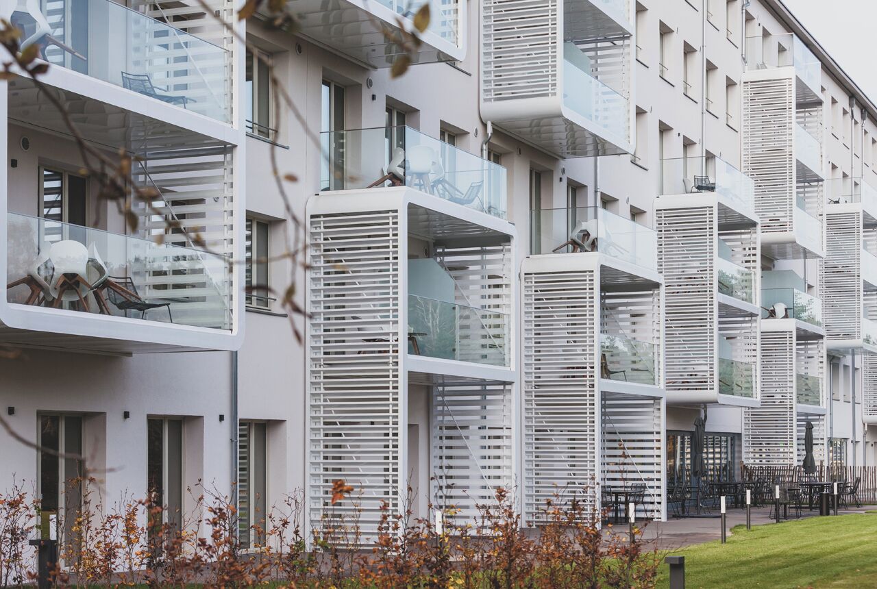 A modern building with multiple balconies and a glass facade.