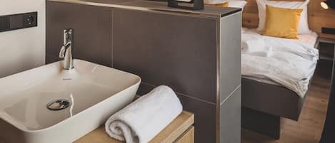 A modern bathroom with a large sink, a mirror, and a towel on the counter.