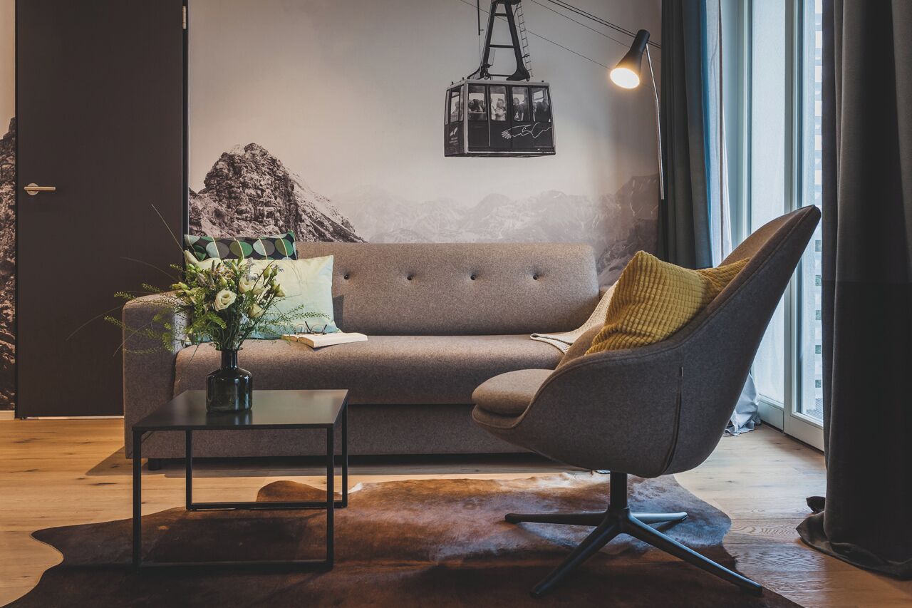 A modern living room with a sofa, armchair, and coffee table.