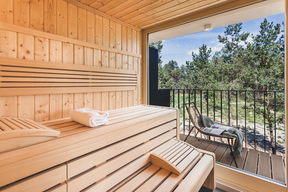 A wooden sauna with benches and a bench with a towel.