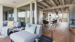 A modern interior with a sofa, coffee table, and dining area. - Mariandl am Meer (Binz)