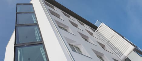 A modern building with a white facade and multiple windows.