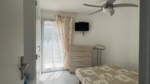 A bedroom with a bed, a ceiling fan, a TV, and a window with curtains. - Barcarès, ile des Pêcheurs, Mas Bord de Marina (Le Barcarès)