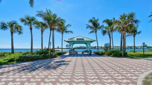 A paved walkway leading to a gazebo with palm trees on either side. - NEW BEACH LISTING, Walk-Beach, Surfing, Scuba, Close-Dining, Wi-Fi (West Palm Beach)