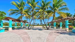 A paved walkway with palm trees and a pergola structure. - NEW BEACH LISTING, Walk-Beach, Surfing, Scuba, Close-Dining, Wi-Fi (West Palm Beach)