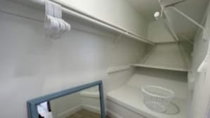 A small, empty walk-in closet with white walls, a blue-framed mirror, and a white basket on a shelf. - NEW BEACH LISTING -Walk To Beach, BBQ Grill, Scuba, Beach Chairs (West Palm Beach)