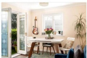 Enjoy meals in the dining area with a table and chairs, surrounded by a potted plant and a vase with flowers.