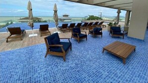 A rooftop lounge with lounge chairs and umbrellas, overlooking a body of water. - Ap Praia de Ouro - Venice Home Club (Picarras)