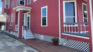 A red two-story house with white trim, a front porch, and a number "3328" on the door. - Beach Retreat Fun In The Sun Cozy Ambiance (Galveston)
