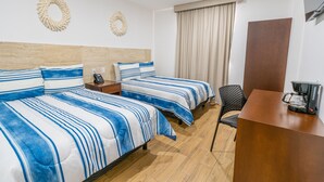 Une chambre d’hôtel avec deux lits, un bureau, une chaise, une machine à café et un rideau.