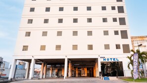 Un hôtel à plusieurs étages, doté d’une façade sobre, d’une entrée centrale et d’une enseigne indiquant qu’il s’agit d’un hôtel.
