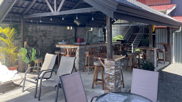 Eine Außenpatio mit Barbereich, Sitzgelegenheiten und Kübelpflanzen.