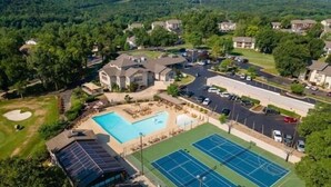 An aerial view of a residential area with a swimming pool, tennis courts, and a parking lot. - Updated condo in Branson w/ golf course view, sleeps 1-4 (Branson)