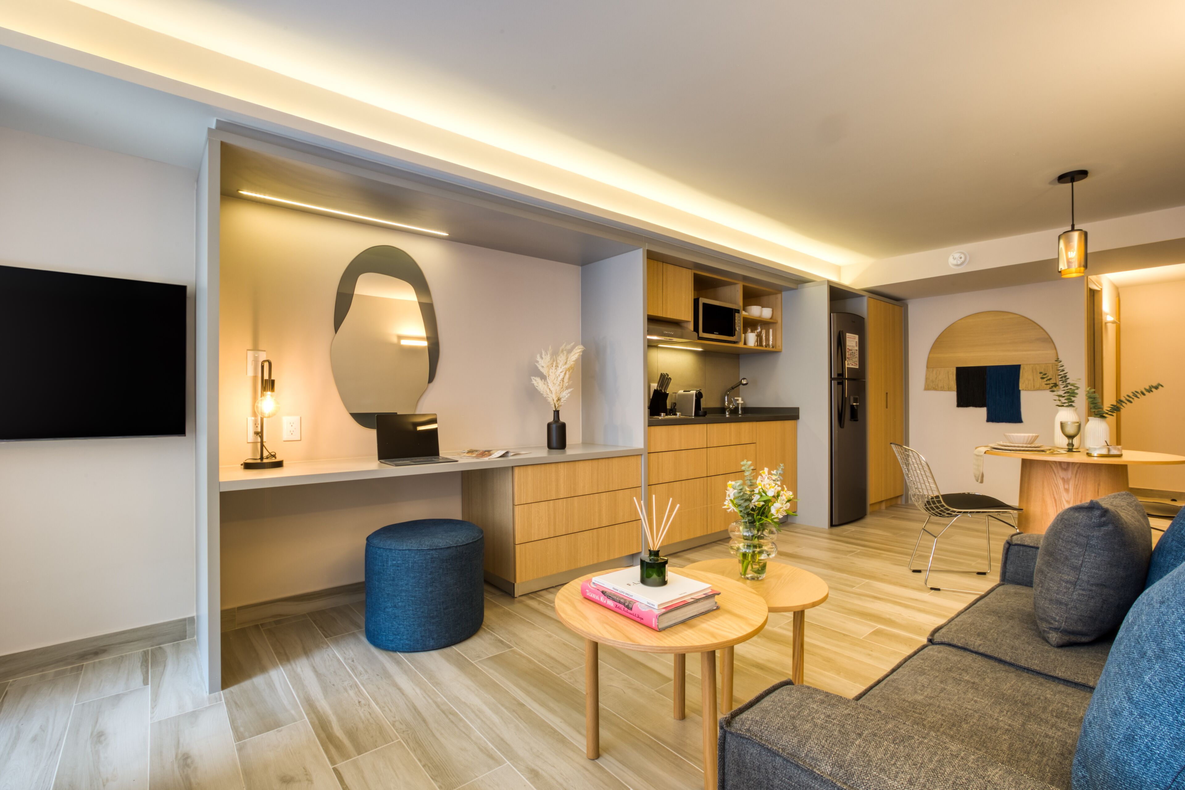 A modern living room with a sofa, a coffee table, and a dining area with a chair and table.