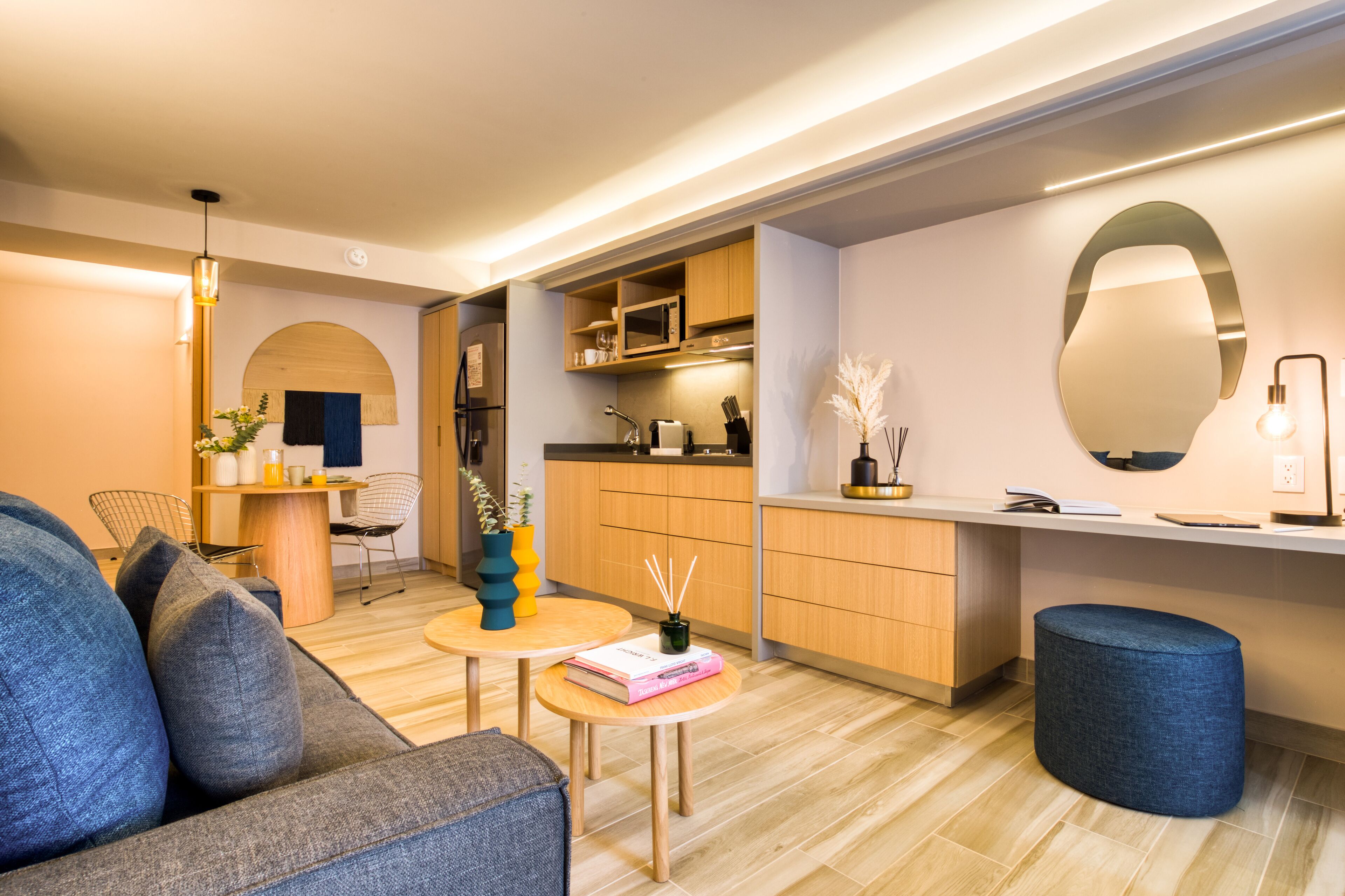A modern living room with a sofa, coffee table, and a small dining area.