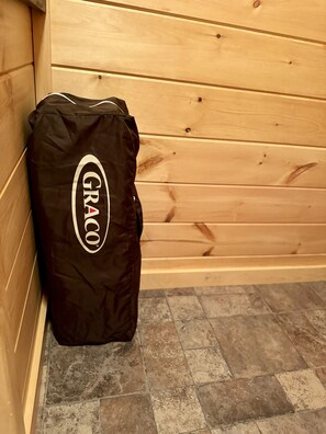 Una bolsa negra de GRACO apoyada contra una pared de madera en una habitación con suelo de baldosas.