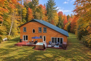 A wooden cabin with a deck, outdoor seating, and a hot tub. - Spacious 4BR / 5 Bath Home - Hot Tub / Pool Table / Ample Private Outdoor Space! (Pittsfield)