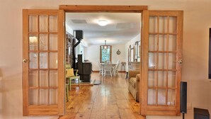 A wooden-floored hallway with a dining area, a kitchen, and a living room. - Spacious 4BR / 5 Bath Home - Hot Tub / Pool Table / Ample Private Outdoor Space! (Pittsfield)