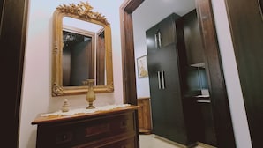 A room with a wooden dresser, a large mirror with an ornate frame, and a dark-colored wardrobe. - STAY Serenity Apartment (Engomi)